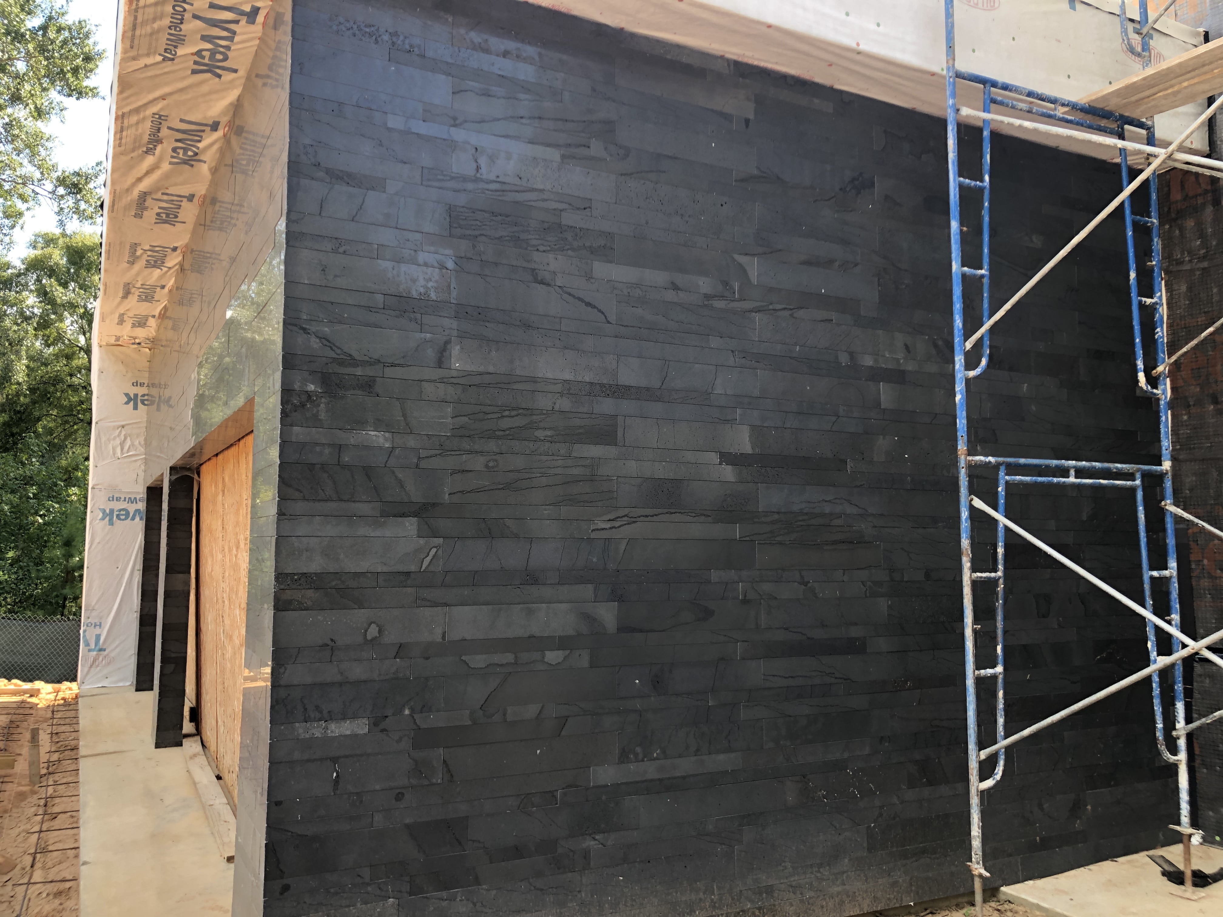 Norstone Graphite Planc Large Format Tile on a residential wall under construction set in a running bond pattern